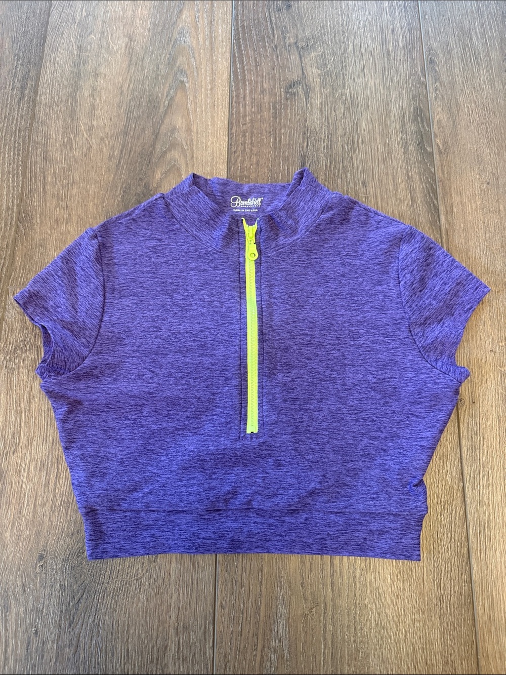 ' Bombshell Sportswear Purple Zip-Front Crop Top with bright yellow zipper